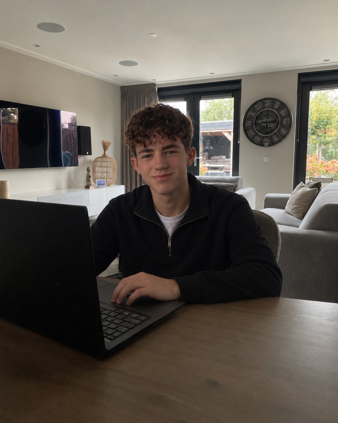 Sean-Luc Haan, de bouwer achter Haan WebWorks, aan tafel achter zijn laptop